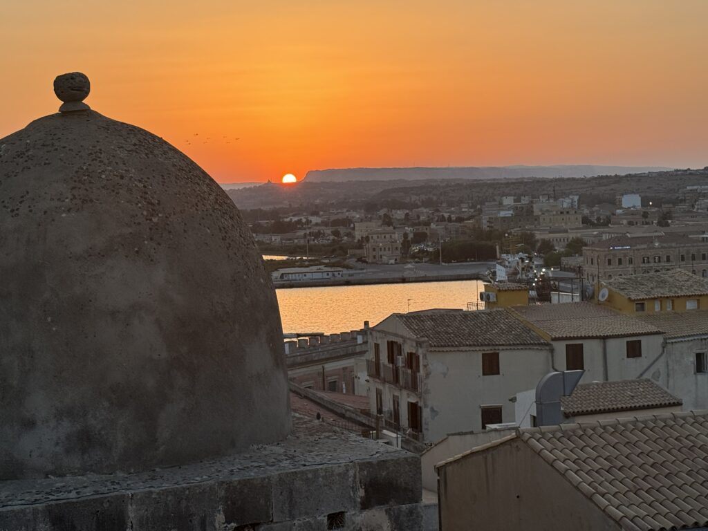 A photo from the Isola di Ortigia, an island that is the historic center of Siracusa, Sicily. The view of Siracusa with Mt. Etna in the background.