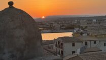 A photo from the Isola di Ortigia, an island that is the historic center of Siracusa, Sicily. The view of Siracusa with Mt. Etna in the background.