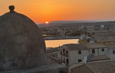 A photo from the Isola di Ortigia, an island that is the historic center of Siracusa, Sicily. The view of Siracusa with Mt. Etna in the background.