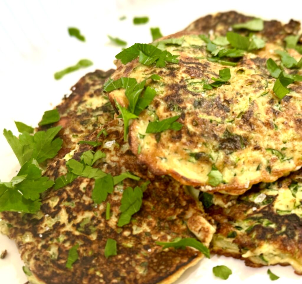 Zucchini and Feta fritters on a serving platter with parsley