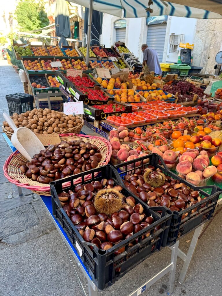 A photo from the Mercato di Ortigia featuring fresh nuts, fruits and vegetables.